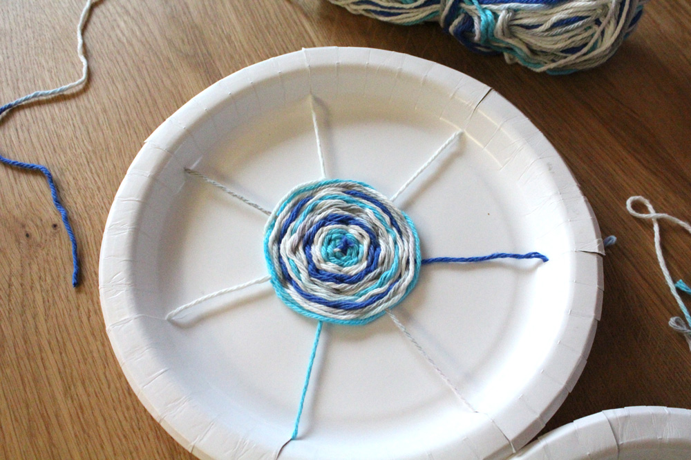 Blue ombre yarn spiral woven in the center of a plate.