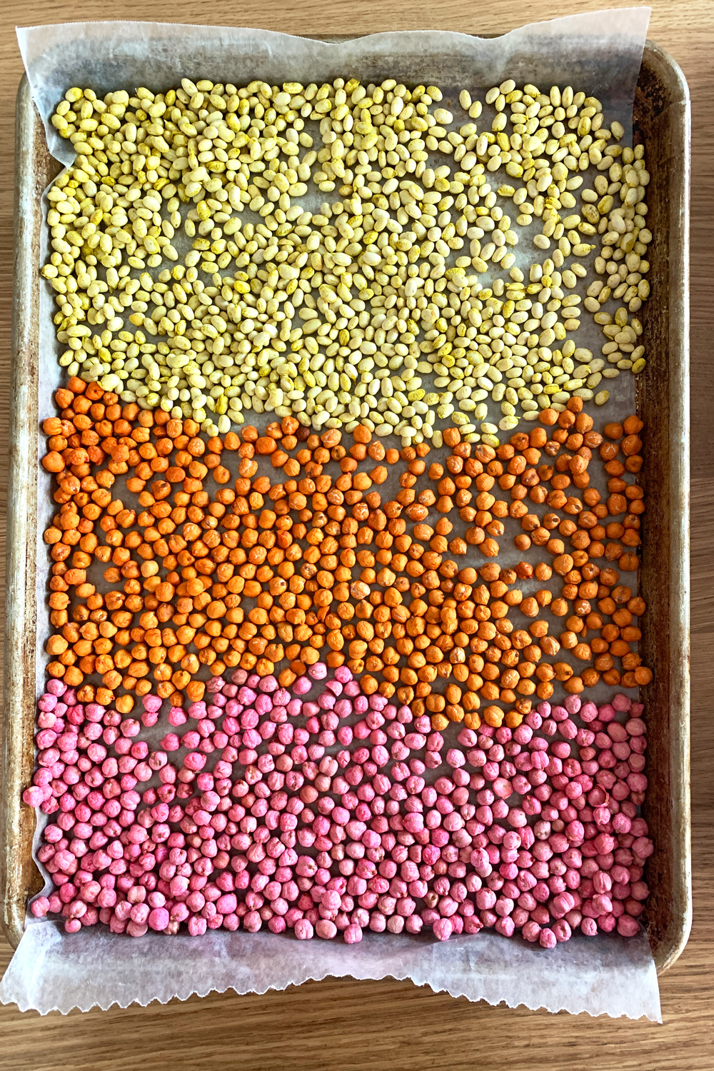 Baking sheet with yellow, orange, and pink beans.
