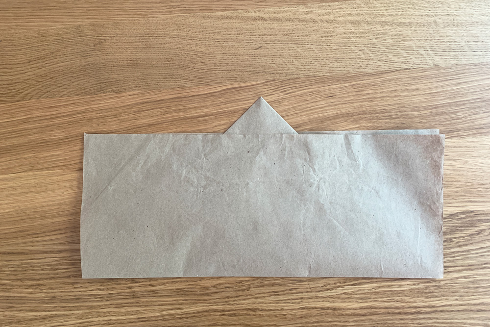 Bottom edge of brown paper folded up over the top triangle.