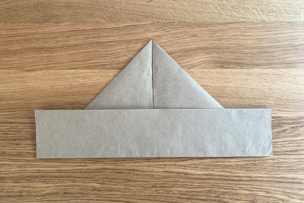 Bottom edge of paper folded back down to resemble a hat brim.