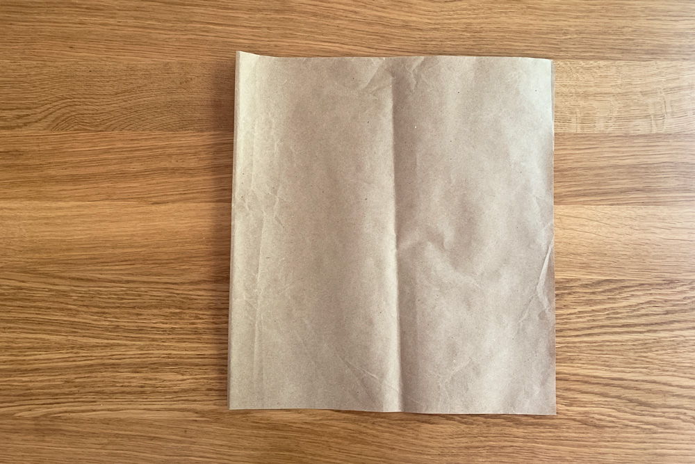 Brown paper folded in half to be square.