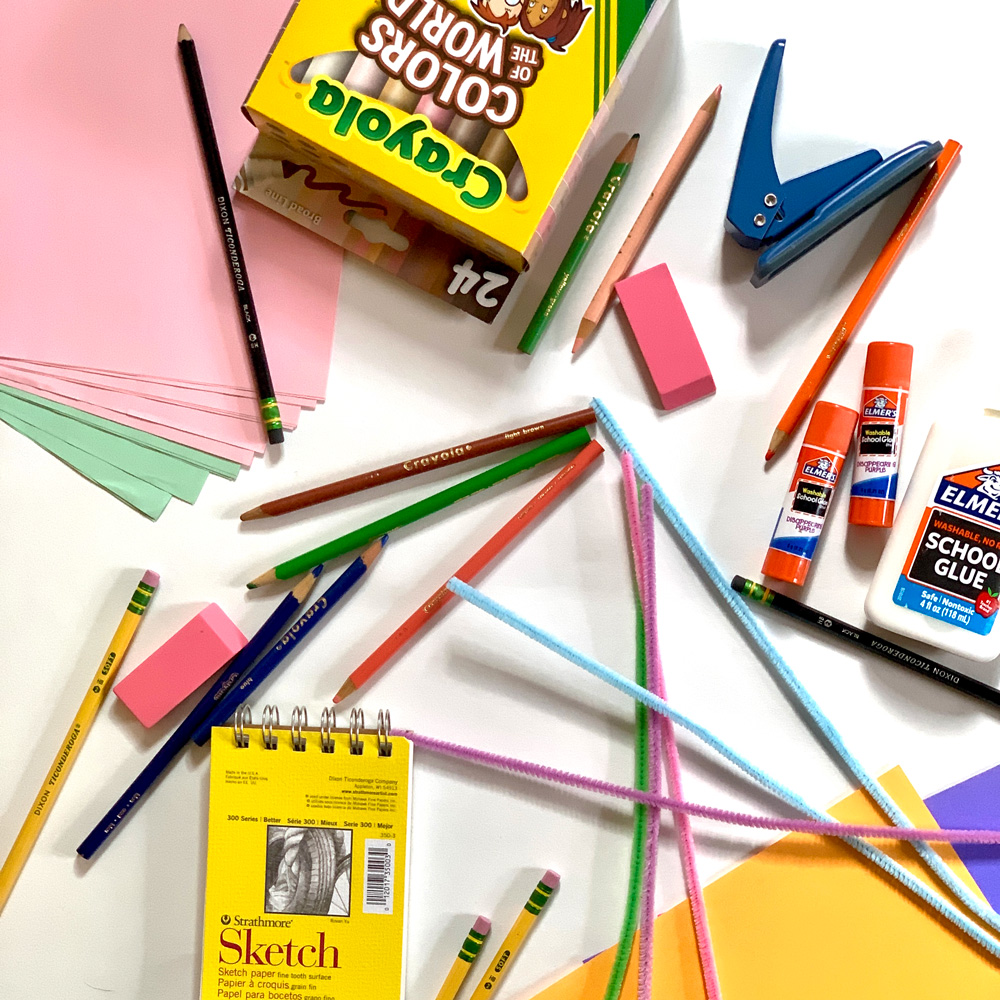 Favorite art and craft supplies including paper, glue, markers, pencils, and pipe cleaner.