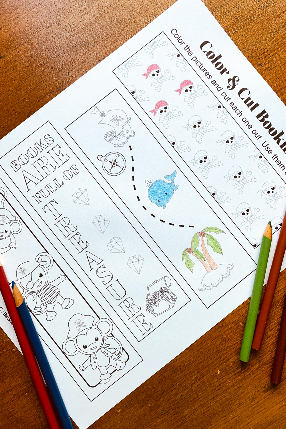 Four bookmarks printed for coloring pirate monkeys, a treasure chest, a map, and a skull pattern.
