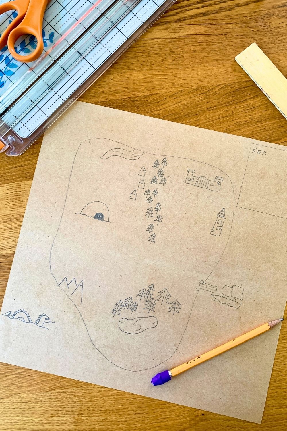 A drawing of a square-ish island on a map with trees, mountains, water, and other pirate-themed details.