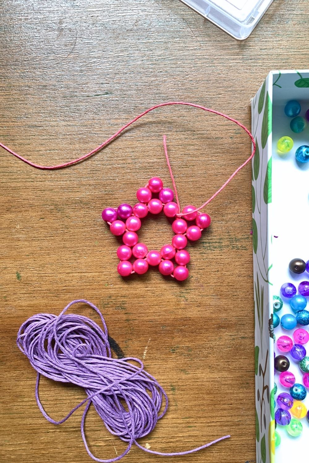 A pink bead star shape made from a circle and triangles.