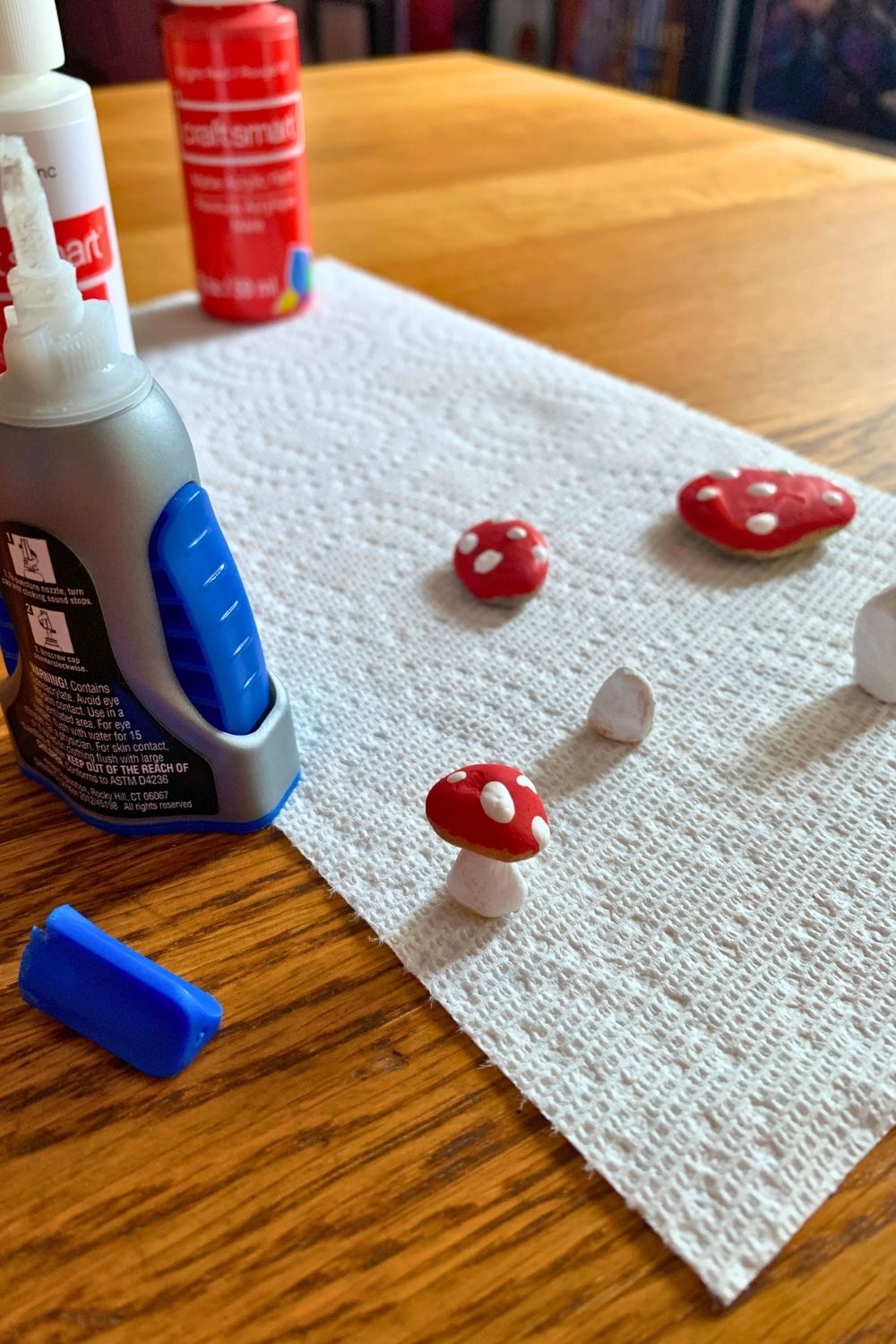 Gluing the red mushroom cap rocks to white stems.