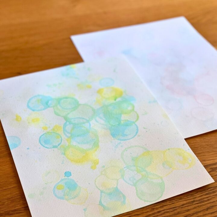 Bubble art on watercolor paper made by blowing paint soap bubbles.