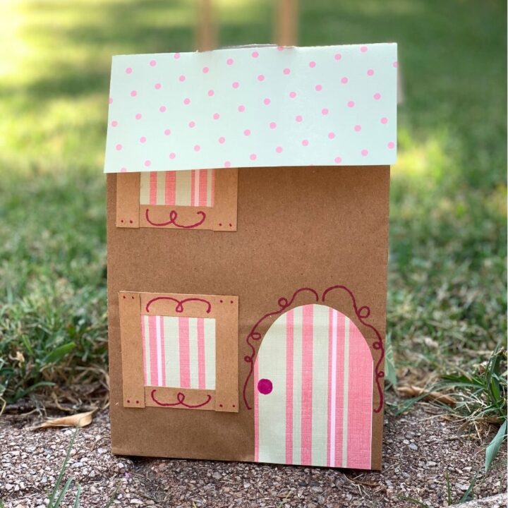 A paper bag house made by gluing paper cutouts to a kraft paper bag.