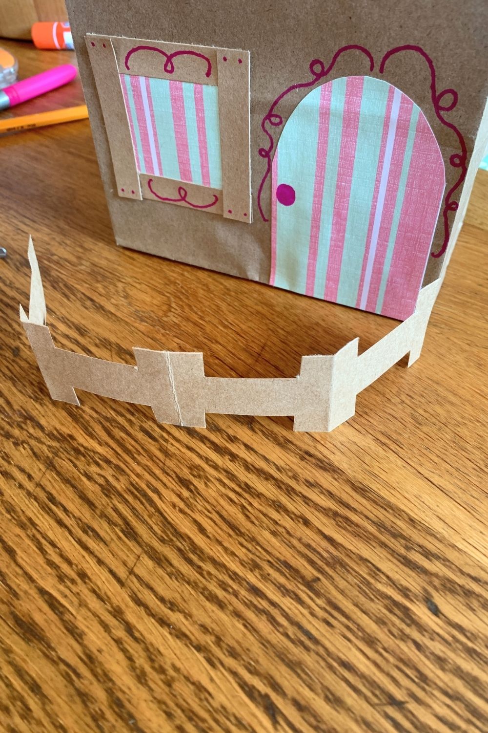A brown paper fence around the front of the paper bag house.