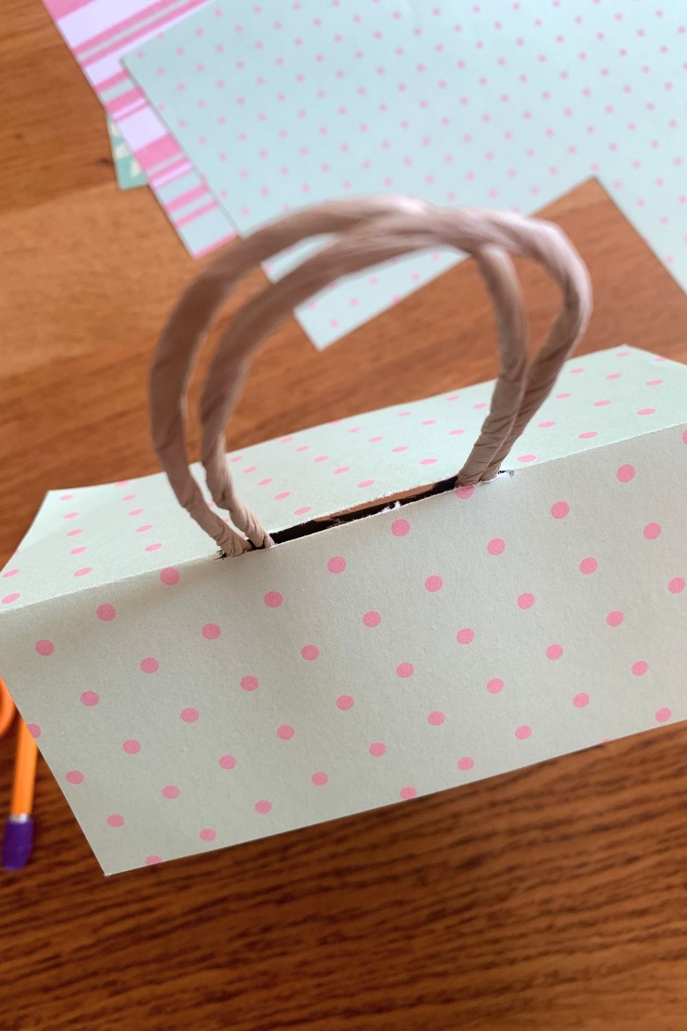 Sliding the paper roof over the handles onto the top of the bag.