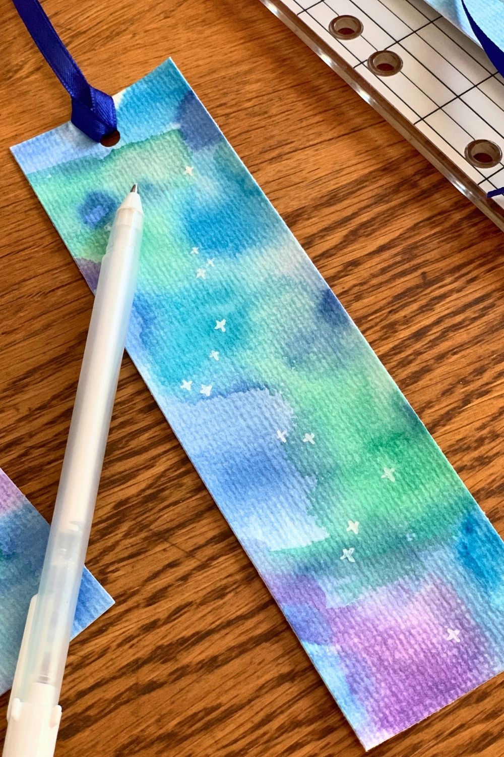 White ink stars scattered in the watercolor space background.